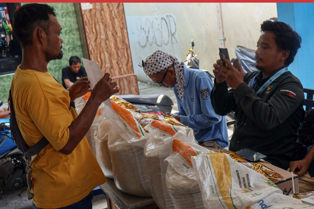 Petugas memotret identitas penerima bantuan sosial saat penyaluran beras dan MinyaKita di Kelurahan Sukamaju, Kota Depok, Jawa Barat, Minggu (26/4/2026). Foto: Yulius Satria Wijaya/ANTARA FOTO