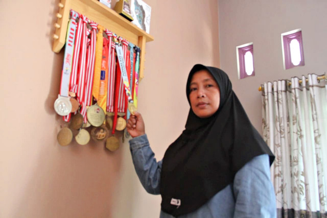 Ibunda Safira, Kholifah menunjukkan medali yang pernah diraih Safira Dwi Meilani sebagai atlet pencak silat. Foto: Vega Ma'arrijil Ula/kumparan