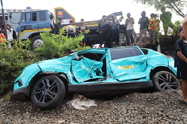 Wujud taksi online yang mogok diperlintasan kereta di dekat Stasiun Bekasi Timur. Foto: Iqbal Firdaus/kumparan