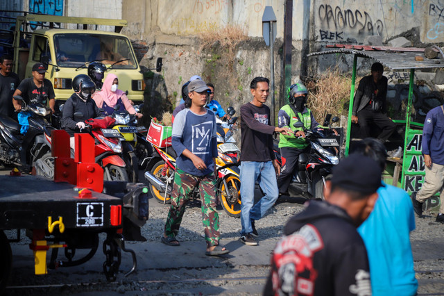 Seorang relawan penjaga perlintasan Kereta Rel Listrik (KRL) mengatur lalu lintas kendaraan di perlintasan sebidang di dekat Stasiun Bekasi Timur, Kota Bekasi, Jawa Barat, Rabu (29/4/2026). Foto: Iqbal Firdaus/kumparan