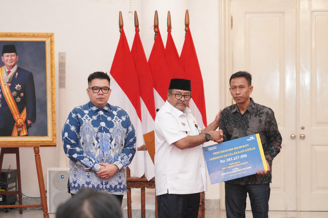 Wakil Gubernur Provinsi DKI Jakarta H. Rano Karno, S.IP (tengah) didampingi Direktur Utama TASPEN Rony Hanityo Aprianto menyerahkan santunan Jaminan Kecelakaan Kerja (JKK) dan Tabungan Hari Tua (THT) senilai total Rp 283.227.000 ke Heris Rusman (kanan) selaku ahli waris Almarhumah Nurlaela, guru SD Negeri Pulo Gebang 11 Petang yang menajdi korban kecelakaan kereta Bekasi Timur di Balai Kota DKI Jakarta, Selasa (28/4). Foto: Dok. TASPEN