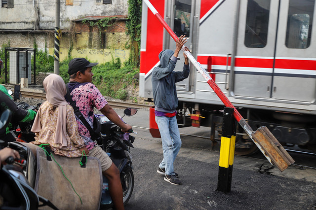 Pengendara melintas di perlintasan sebidang di kawasan Duren Jaya, Kota Bekasi, Kamis (30/4/2026), setelah PT KAI memasang palang pintu pembatas di lokasi tersebut. Foto: Iqbal Firdaus/kumparan