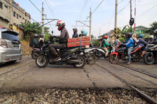 Pengendara melintas di perlintasan sebidang di kawasan Duren Jaya, Kota Bekasi, Kamis (30/4/2026), setelah PT KAI memasang palang pintu pembatas di lokasi tersebut. Foto: Iqbal Firdaus/kumparan
