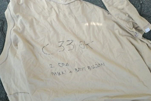 Penghuni Apartemen Mediterania, Tanjung Duren, Grogol Petamburan, Jakarta Barat, yang terjebak akibat kebakaran melempar sepotong baju berisi tulisan, Kamis (30/4/2026) pagi. Foto: Dok. Antara