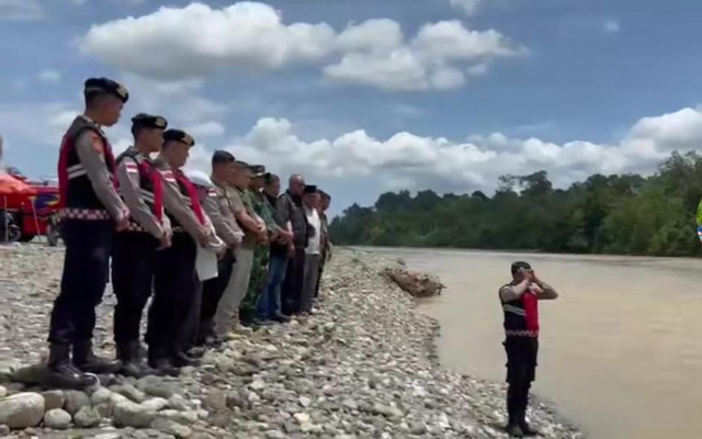 Momen personel Polres Nagan Raya melantunkan azan di pinggir sungai Krueng Kila, Kabupaten Nagan Raya, Aceh saat proses pencarian korban tenggelam. Minggu (26/4/2026). Foto: Dok. Istimewa