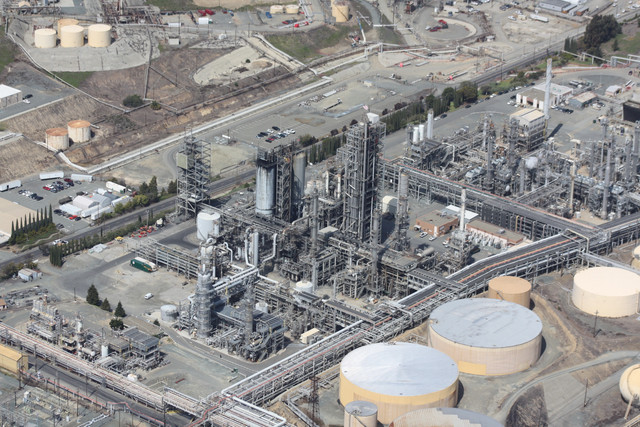 Kilang minyak dengan jaringan pipa dan tangki penyimpanan besar, menunjukkan aktivitas industri energi yang kompleks dan perannya dalam distribusi bahan bakar. Source: https://pixabay.com/id/photos/kilang-minyak-udara-gas-alam-109025/