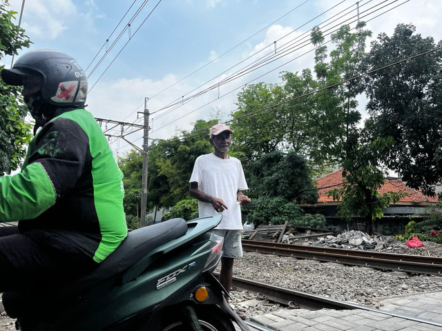 Babeh Ismail atau yang kerap disapa Babeh Is penjanga lintasan sebidang di kawasan Tebet Timur Dalam, Sabtu (2/5/2026). Foto: Rayyan/Kumparan