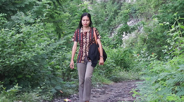 Seorang guru honorer Yustina Yuniarti berjalan menuju SDK Wukur di Desa Sikka, Kecamatan Lela, Kabupaten Sikka, Flores, NTT. Foto: kumparan