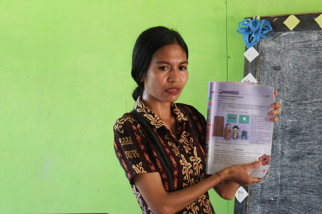 Seorang guru honorer Yustina Yuniarti berjalan menuju SDK Wukur di Desa Sikka, Kecamatan Lela, Kabupaten Sikka, Flores, NTT. Foto: kumparan