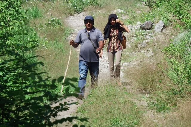 Seorang guru honorer Yustina Yuniarti berjalan menuju SDK Wukur di Desa Sikka, Kecamatan Lela, Kabupaten Sikka, Flores, NTT. Foto: kumparan