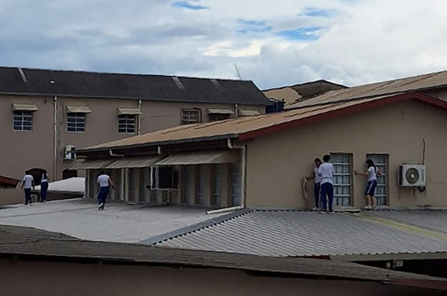 Siswa-siswa sekolah Sao Jose berlindung di atap saat seorang remaja menyerang sekolah tersebut dan menembak mati dua staf, serta melukai seorang staf lainnya dan seorang siswa di Rio Branco, Acre, Brasil (5/5/2026). Foto: Stringer/AFP