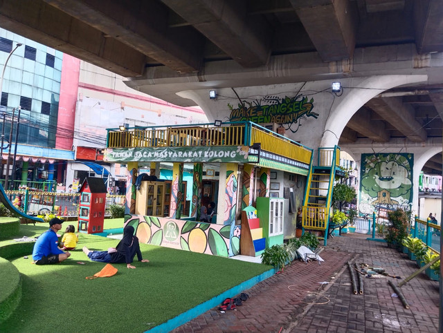 Foto menggambarkan suasana taman baca masyarakat di Kolong flyover, foto tersebut diambil langsung oleh penulisnya. 