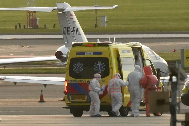 Seseorang berpakaian hazmat (kedua kanan) dikawal menuju ambulans dari pesawat medis yang diduga membawa penumpang kapal pesiar MV Hondius yang terinfeksi hantavirus di Bandara Schiphol, Amsterdam, Belanda (6/5/2026). Foto: LINA SELG/AFP