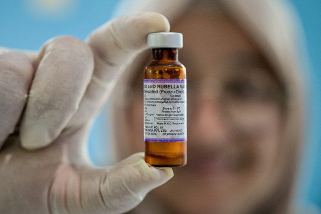 Petugas kesehatan memegang vaksin campak-rubella sebagai bagian dari program kesehatan pemerintah untuk memerangi penyakit anak di Surabaya (6/5/2026). Foto: Juni Kriswanto/AFP