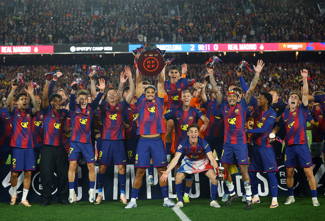 Ronald Araujo dari FC Barcelona mengangkat trofi saat merayakan kemenangan bersama rekan-rekan setimnya setelah memenangkan LaLiga pada 10 Mei 2026. Foto: REUTERS/Albert Gea