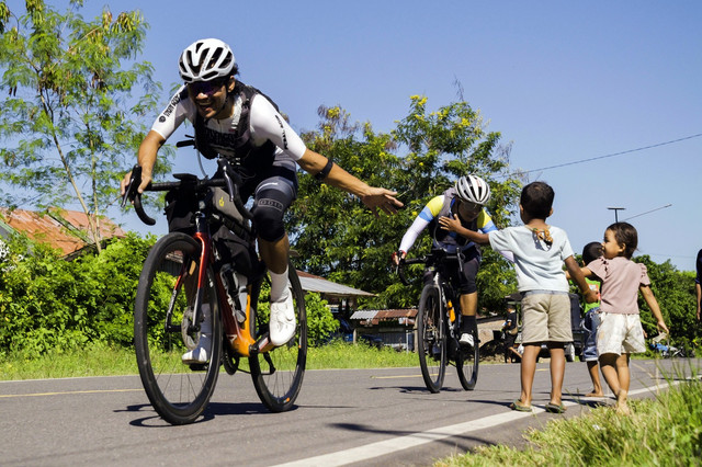 Ultra cyclist sejenak terhibur oleh keramahan anak-anak di tengah upaya taklukkan tanjakan terjal di pulau Flores. Foto: Dok. Istimewa