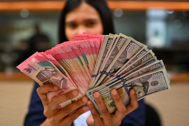 Karyawan memperlihatkan uang pecahan rupiah dan dolar Amerika Serikat (AS) di gerai penukaran mata uang asing Ayu Masagung, Jakarta, Selasa (12/5/2026). Foto: Indrianto Eko Suwarso/ANTARA FOTO