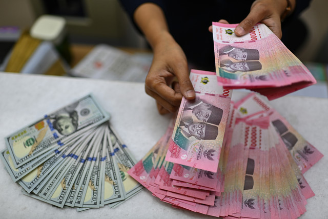 Karyawan menghitung uang pecahan rupiah dan dolar Amerika Serikat (AS) di gerai penukaran mata uang asing Ayu Masagung, Jakarta, Selasa (12/5/2026).  Foto: Indrianto Eko Suwarso/ANTARA FOTO