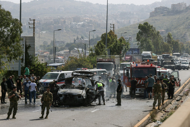 Petugas tanggap darurat bekerja di lokasi serangan drone Israel yang menargetkan sebuah kendaraan di jalan raya dekat kota Jiyeh, selatan Beirut, Lebanon, Rabu (13/5/2026). Foto: Mahmoud Zayyat/AFP
