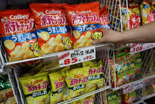 Seorang karyawan menambahkan stok keripik kentang Calbee ke rak di salah satu toko di Tokyo, Jepang, Selasa (12/5/2026). Foto: Issei Kato/REUTERS