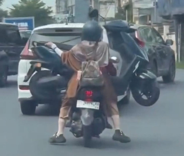 Emak-emak mengangkut sepeda motor menggunakan sepeda motor di Makassar, Sulawesi Selatan. Foto: Istimewa