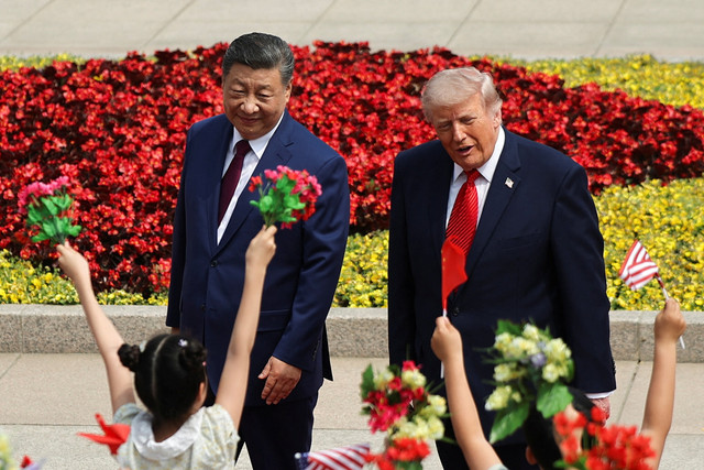 Anak-anak memegang bendera China dan AS saat Presiden AS Donald Trump mengikuti upacara penyambutan bersama Presiden China Xi Jinping di Balai Besar Rakyat di Beijing, China (14/5/2026). Foto: Maxim Shemetov/REUTERS