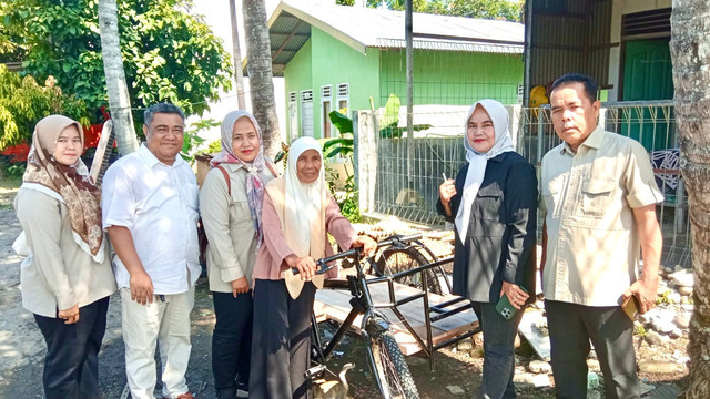 Ema (66) tampak bahagia saat menerima bantuan satu unit becak kayuh baru dari Andre Rosiade. Foto: Istimewa