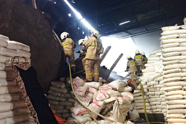 Sejumlah petugas berada di sebuah pabrik yang terbakar di kawasan Cengkareng, Jakarta Barat, Selasa (19/5/2026). Foto: Dok. Gulkarmat Jakarta Barat