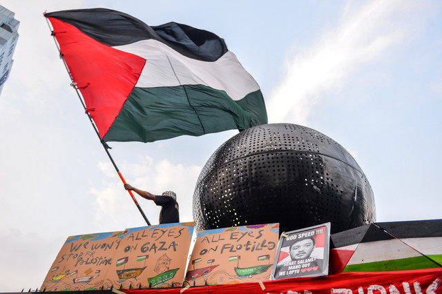 Massa dari Solidaritas Seni untuk Palestina mengibarkan bendera Palestina saat mengikuti aksi solidaritas bagi WNI dan Jurnalis yang diculik Israel di Jalan Asia Afrika, Bandung, Jawa Barat, Selasa (19/5/2026). Foto: Raisan Al Farisi/ANTARA FOTO