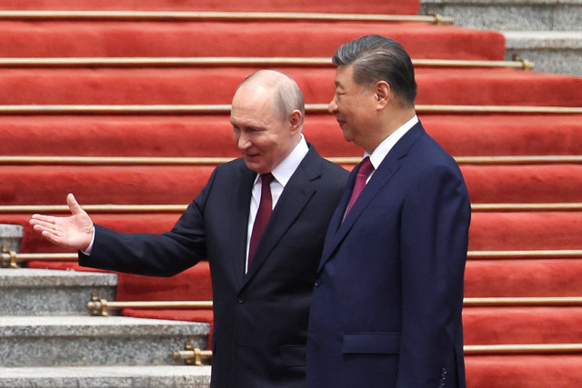 Presiden Rusia Vladimir Putin berjalan bersama Presiden Tiongkok Xi Jinping selama upacara penyambutan di Balai Besar Rakyat di Beijing, Tiongkok, 20 Mei 2026. Foto: REUTERS/Maxim Shemetov/Pool
