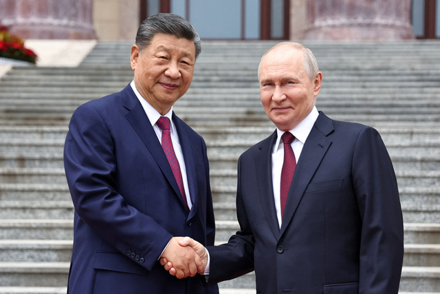 Presiden Rusia Vladimir Putin berjabat tangan dengan Presiden Tiongkok Xi Jinping selama upacara penyambutan di Balai Besar Rakyat di Beijing, Tiongkok, 20 Mei 2026. Foto: Sputnik/Alexander Kazakov/Pool via REUTERS