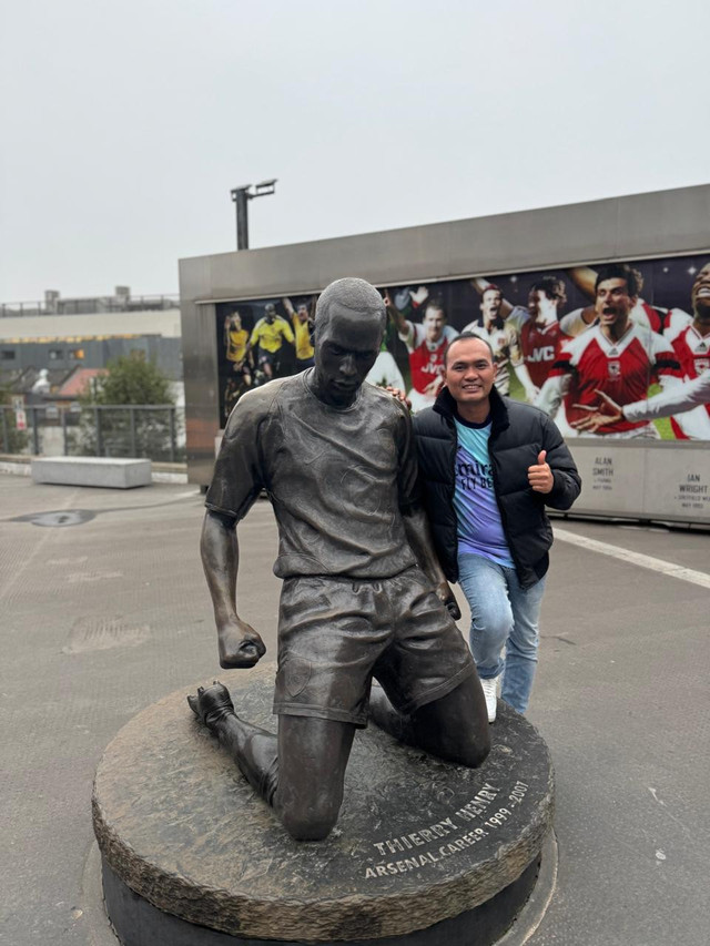 Sumber foto: Dokumentasi pribadi. Fans Arsenal berfoto bersama patung legenda klub di Emirates Stadium.