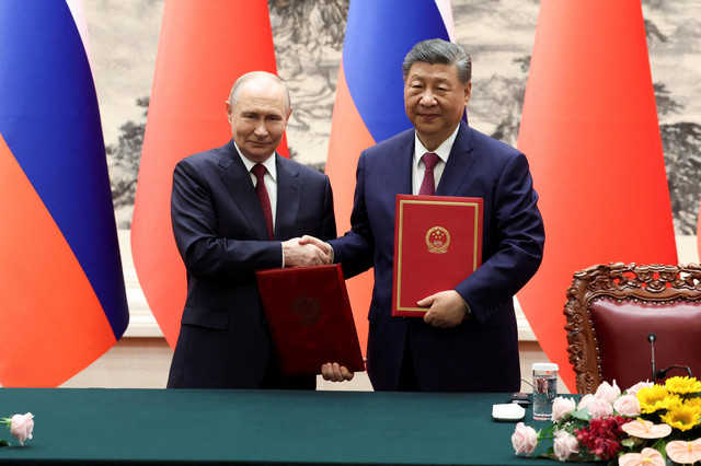 Presiden Rusia Vladimir Putin berjabat tangan dengan Presiden China Xi Jinping usai menghadiri pertemuan bilateral di Balai Besar Rakyat di Beijing, China, Rabu (20/5/2026). Foto: Maxim Shemetov/Pool/REUTERS