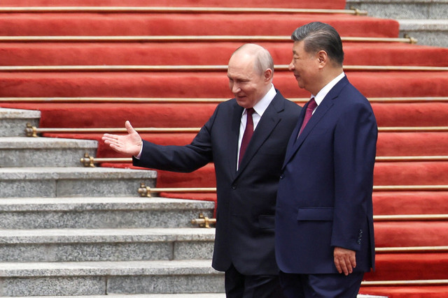 Presiden Rusia Vladimir Putin berbincang dengan Presiden China Xi Jinping selama upacara penyambutan di Great Hall of the People, Beijing, China, Rabu (20/5/2026). Foto: Maxim Shemetov/Pool/REUTERS