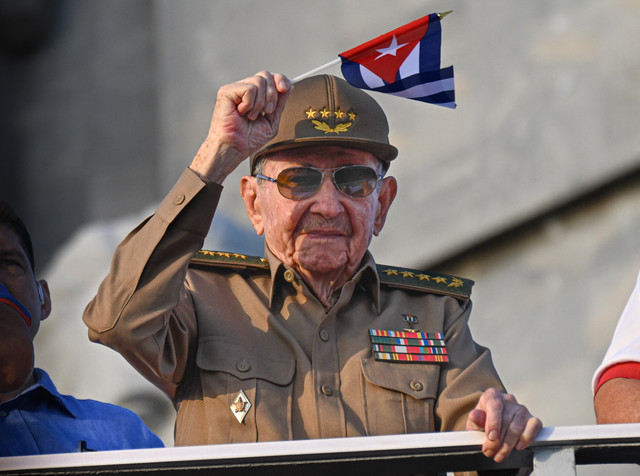 Mantan Presiden Kuba Raul Castro mengibarkan bendera nasional Kuba dalam peringatan Hari Buruh Internasional (May Day) di Alun-Alun Revolusi Havana, Kuba (1/5/2025). Foto: Yamil Lage/AFP