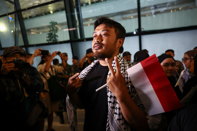 Thoudy Badai, salah satu anggota Indonesia dari Armada Global Sumud yang menuju Gaza, yang ditahan oleh pasukan Israel setelah kapal-kapal armada tersebut dicegat di perairan internasional Laut Mediterania, memberi isyarat saat tiba di Bandara. Foto: REUTERS/Willy Kurniawan