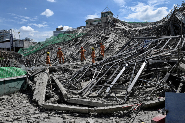 Petugas penyelamat mencari korban selamat di antara puing-puing saat sebuah gedung sembilan lantai yang sedang dibangun runtuh di Balibago, Angeles City, Pampanga, Filipina, 24 Mei 2026. Foto: Reuters/Noel Celis