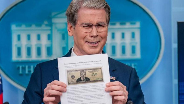Menteri Keuangan AS, Scott Bessent, memperlihatkan sebuah artikel berita dengan ilustrasi uang kertas yang menampilkan wajah Trump.