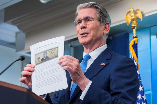 Menteri Keuangan AS Scott Bessent mengangkat artikel Washington Post tentang usulan uang kertas 250 dolar dengan potret Presiden AS Donald Trump saat konferensi pers di Gedung Putih di Washington, D.C., AS, Kamis (28/5/2026). Foto: Kylie Cooper/REUTERS 
