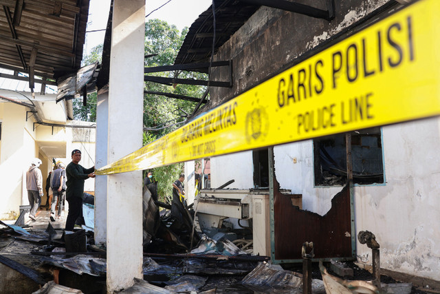 Petugas memasang garis polisi di gedung Rumah Sakit Umum Daerah (RSUD) Syekh Yusuf Gowa yang terbakar di Kabupaten Gowa, Sulawesi Selatan, Jumat (29/5/2026). Foto: Arnas Padda/ANTARA FOTO