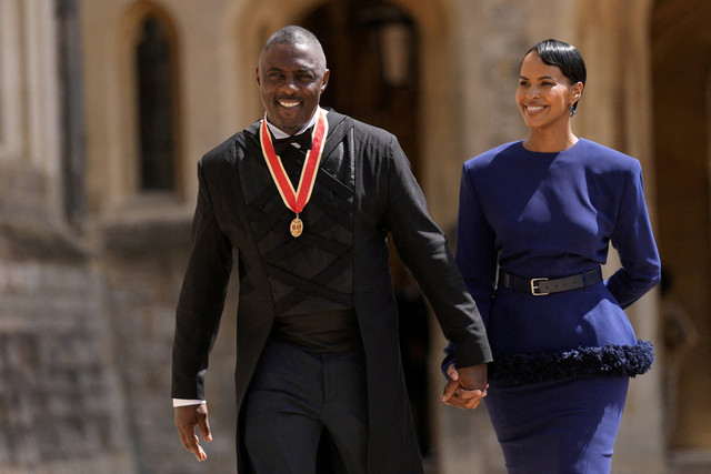 Sir Idris Elba, aktivis, aktor, dan musisi, berjalan bersama istrinya, Sabrina Dhowre Elba, setelah dianugerahi gelar Ksatria oleh Raja Charles III di Kastil Windsor, Windsor, Inggris, Selasa (2/6/2026). Foto: Andrew Matthews/Pool via REUTERS