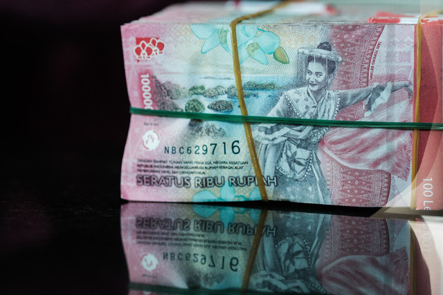 Sejumlah uang kertas rupiah Indonesia difoto di sebuah tempat penukaran mata uang di Jakarta, Kamis (4/6/2026), setelah nilai tukar rupiah melemah hingga melampaui angka 18.000 per dolar AS untuk pertama kalinya. Foto: Yasuyoshi Chiba/AFP
