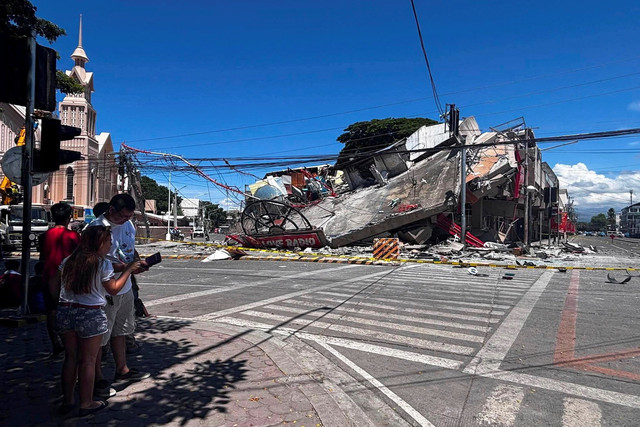 Warga berdiri di dekat bangunan yang runtuh setelah gempa berkekuatan 7,8 magnitude di General Santos, Filipina, 8 Juni 2026. Foto: REUTERS/Edwin Espejo