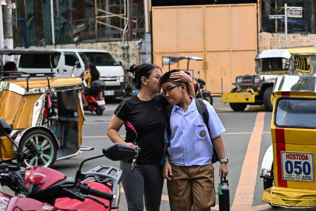 Seorang orang tua mendampingi anaknya saat kelas dibuka untuk tahun ajaran baru di sebuah sekolah dasar di Manila, Filipina, Senin (8/6/2026). Foto: Jam Sta Rosa/AFP