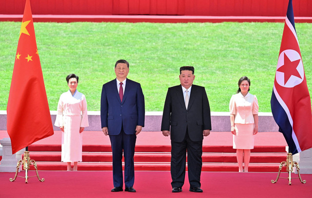 Presiden Tiongkok Xi Jinping dan pemimpin Korea Utara Kim Jong Un menyaksikan parade pasukan saat Kim menggelar upacara penyambutan untuk Xi di Lapangan Kim Il Sung, Pyongyang, Korea Utara, Senin (8/6/2026). Foto: XINHUA/via REUTERS