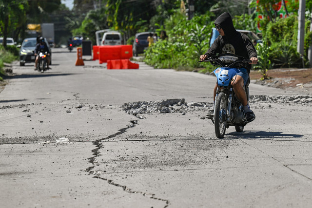 Sebuah jalan mengalami kerusakan parah akibat gempa bumi berkekuatan magnitudo 7,8 di General Santos City, Filipina, Selasa (9/6/2026). Foto: Jam Sta Rosa/AFP