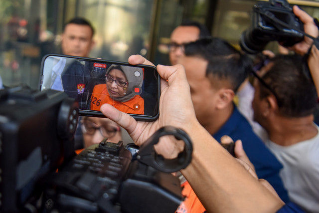 Gawai wartawan merekam tersangka kasus dugaan suap pengaturan temuan pemeriksaan BPK di Pemkab Muara Enim, Titin Rita Lestari saat berjalan menuju mobil tahanan usai menjalani pemeriksaan di Gedung Merah Putih KPK, Jakarta, Kamis (11/6/2026). Foto: Rio Feisal/ANTARA