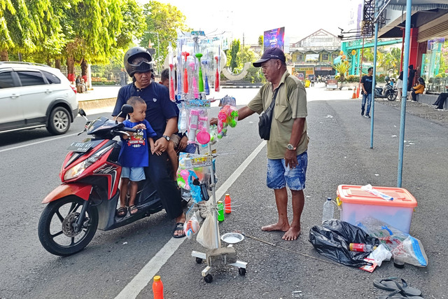 Witono menawarkan barang dagangannya di kawasan Alun-alun Simpang Tujuh Kudus. Foto: Vega Ma'arrijil Ula/kumparan