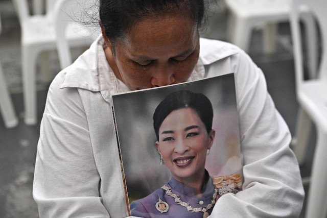 Seorang pelayat menangis sembari memegang foto Putri Thailand Bajrakitiyabha Mahidol di depan RS Chulalongkorn, Bangkok (12/6/2026). Foto: Lillian Suwanrumpha/AFP
