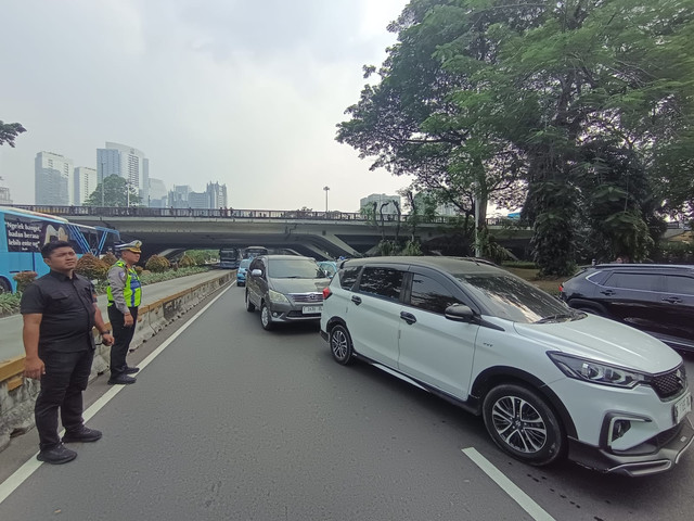 Polisi di Semanggi mengarahkan mobil ke Jalan Gatot Subroto karena jalan Jend Sudirman ditutup akibat demo mahasiswa di HI, Jumat (12/6/2026). Foto: Jamal Ramadhan/kumparan